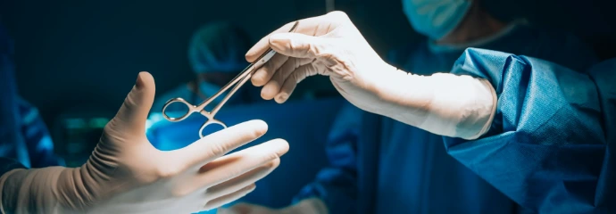 a person in a surgical gown is holding a pair of scissors
